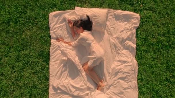 Вид сверху женский сон на зеленой траве — стоковое видео