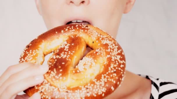 Close up rosto jovem mulher comer pretzel — Vídeo de Stock
