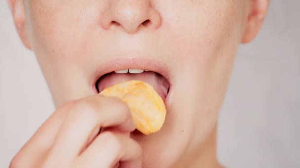 Vicino faccia giovane donna mangiare patatine fritte — Video Stock