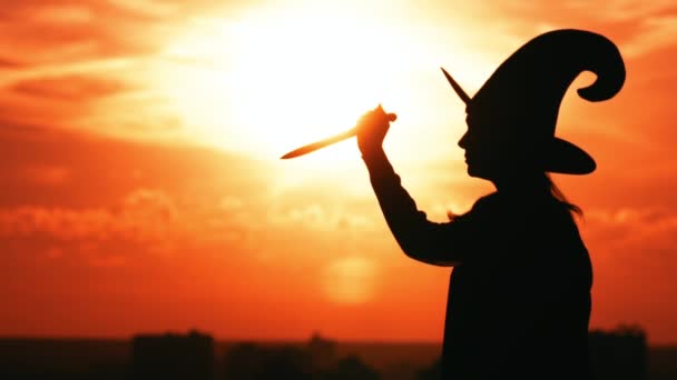 Side view girl in a witch costume hold knife cityscape slow motion — Stock Video