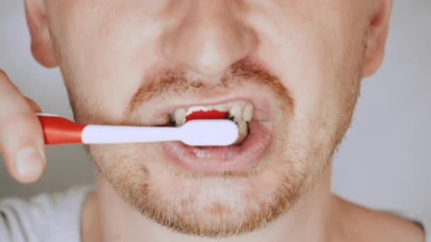 Zbliżyć twarz uczciwy człowiek za pomocą szczoteczki do zębów — Wideo stockowe