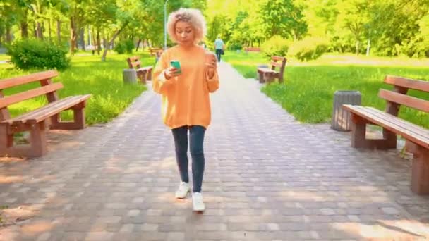 Афроамериканська щаслива дівчина розмовляє з другом по телефону — стокове відео