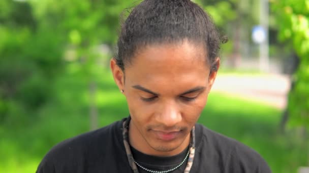Junger Mann mit gemischter Rasse blickt lachend in die Kamera — Stockvideo