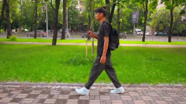 Side view student playing game on smartphone on the run — Stock Video