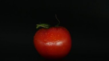 Yakın çekim rotasyon kırmızı domates su damlaları ile kaplı. Taze ve sulu, diyetler için mükemmel. 4k çözünürlük, döngü video.
