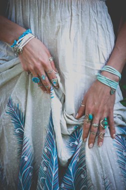 Genç kadının ellerini tutun elbise ayrıntılarla boho aksesuar yüzük ve bilezik moda açık yaz günü yakın çekim