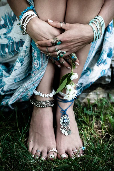 波西米亚时尚细节女人的手和赤脚在草地上有很多波希米亚风格的 Jewrly 戒指手镯夏季日 — 图库照片