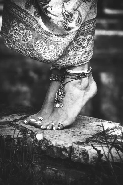 女子夏季波西米亚时尚风格赤脚与珠宝脚镯和戒指站在石头户外生物武器 — 图库照片