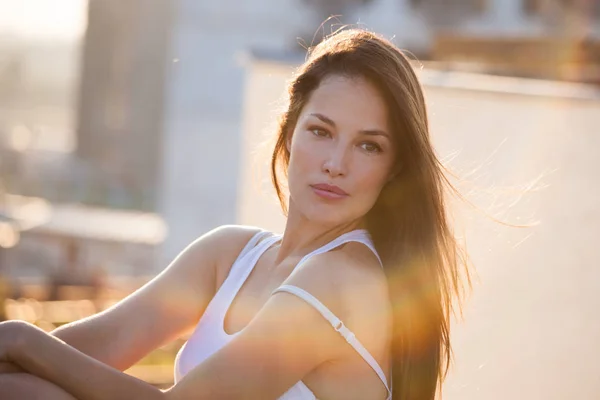 Pretty city girl portrait at sunset backlight at top of building — Stock Photo, Image