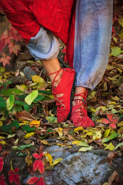 closeup of woman feet in yoga  pose in colorful autumn leaves outdoor day shot