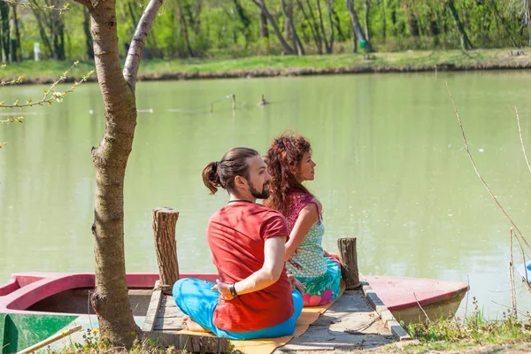 Young man and woman practice yoga outdoor by the lake sunny summ — Stock Photo, Image