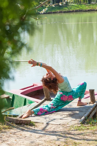 Giovane donna pratica yoga all'aperto vicino al lago stile di vita sano — Foto Stock