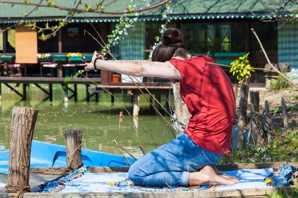 Fiatal férfi gyakorlat jóga nyári nap a tó nyújtózkodó oldalán v — Stock Fotó