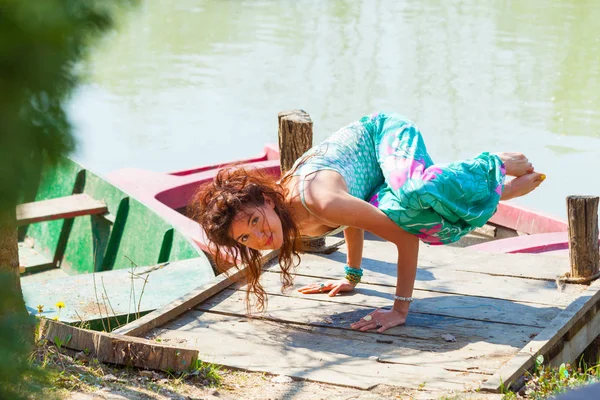 Jeune femme pratique le yoga en plein air au bord du lac pose d'équilibre sur ha — Photo
