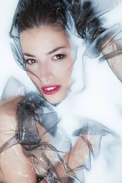 관능적 인 여자 초상화 와 검정 명주 그물 에 우유 목욕 — 스톡 사진