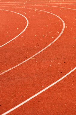 atletik kırmızı koşu pistleri beyaz çizgiler ve bazı yaprakları yontma 