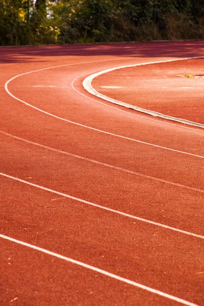 Athletic red running tracks whit white lines outdoors sunny day — Stock Photo, Image