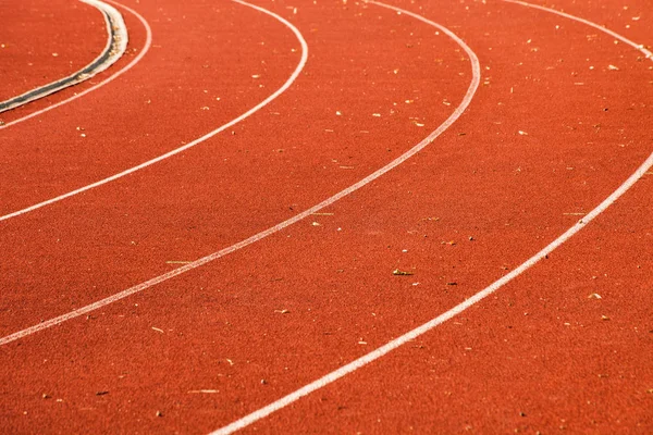 Closeup of athletic red running tracks whit white lines and some — Stock Photo, Image