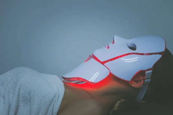 Mujer con luz led terapia facial y cuello máscara de belleza foto — Foto de Stock