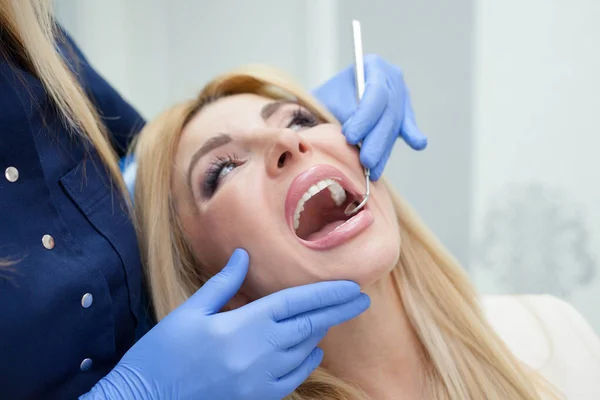 Žena u zubaře při prohlídce šeku — Stock fotografie