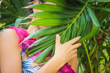 Kadın yüzü palmiye ağacının arkasına saklanmış renkli bir elbise giymiş Jamaika 'nın tropik adası 