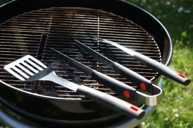 Çatal bıçak takımı ile bahçede kömür ızgara sosis Barbekü için
