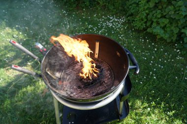 Bir sosis ile bahçede Kömür Barbekü ızgara ızgara açık ateşte