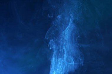 Stüdyoda farklı renklerde sigara içiliyor. Renkli bir flaş ışığı var.