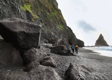 iki turist dağlarda Icelan siyah bir plajda yürümek