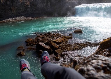 Bacaklarını aşağı, görünümü onun bacaklarını Özgürlük kavramı asılı turistik bir uçurum Nehri yakınında oturuyor.