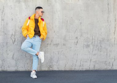 sarı giysili beton duvara yakın duran moda adam