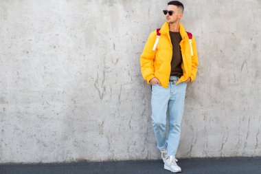 sarı giysili beton duvara yakın duran moda adam