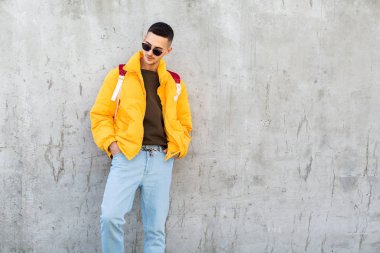 sarı giysili beton duvara yakın duran moda adam