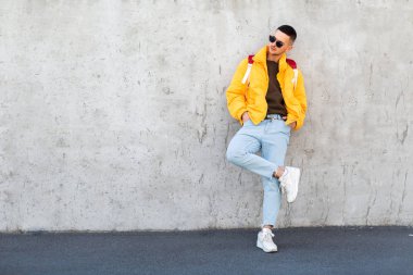 sarı giysili beton duvara yakın duran moda adam