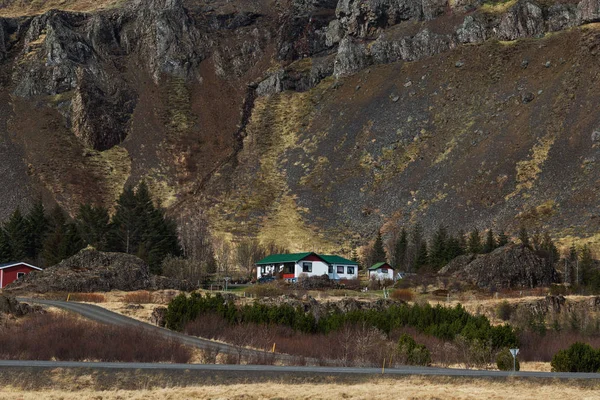 アイスランドの丘の曲がりを見下ろす家山 — ストック写真
