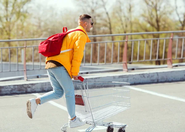 Modemann Mit Sonnenbrille Und Gelber Jacke Springt Einem Einkaufswagen Vom — Stockfoto