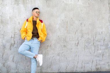 sarı giysili beton duvara yakın duran moda adam
