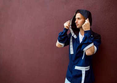 Mavi giysili bir Viyola duvarının yakınında duran moda adam