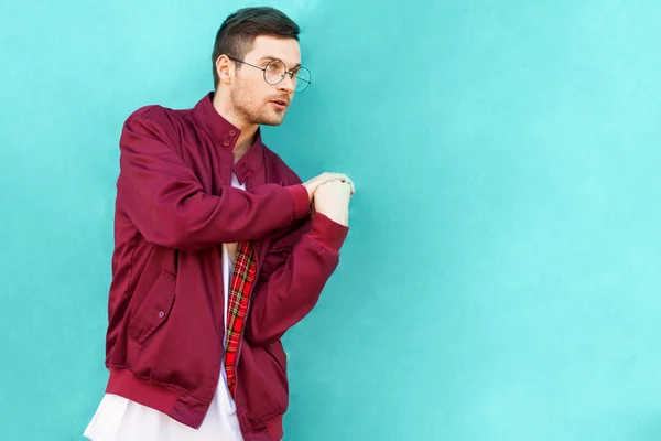 壁の近くのメガネでファッションの流行に敏感な男ポーズ酸味の波の色 — ストック写真