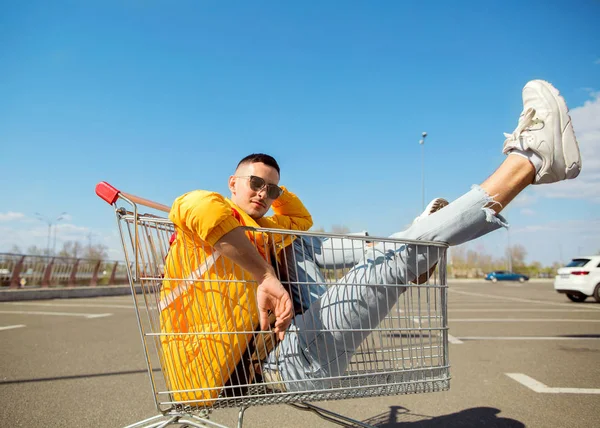 moda erkek güneş gözlüğü ve sarı ceket bir sepeti süpermarket Park Gıda üzerinden atlamak