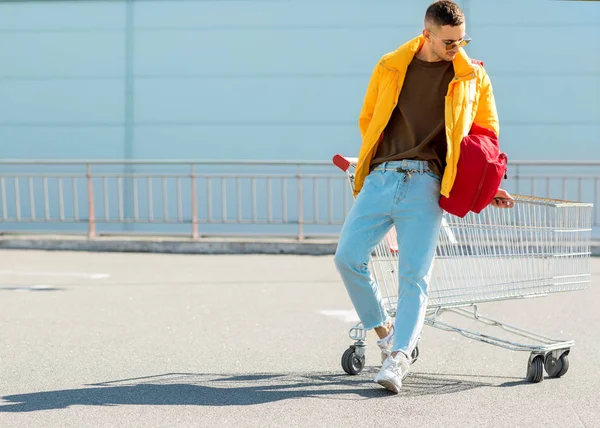 moda erkek güneş gözlüğü ve sarı ceket bir sepeti süpermarket Park Gıda üzerinden atlamak