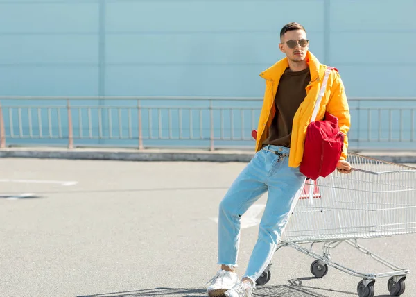 moda erkek güneş gözlüğü ve sarı ceket bir sepeti süpermarket Park Gıda üzerinden atlamak