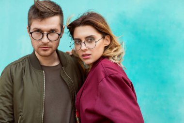 moda çift bordo elbise mavi ahşap duvara poz ile onların bardaklarda