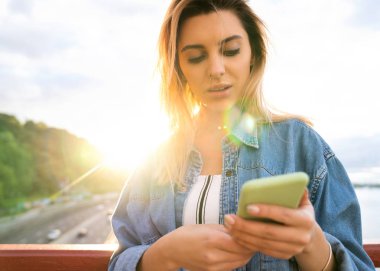 gün batımında kız serbest meslek telefon ve eserler üzerinde konuşuyor