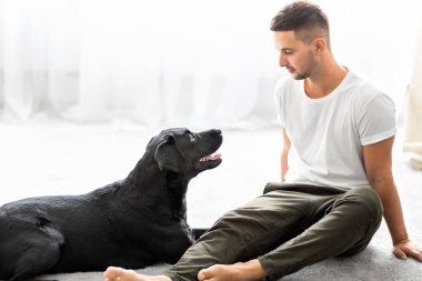 adam köpeğiyle ev oynarken oturma