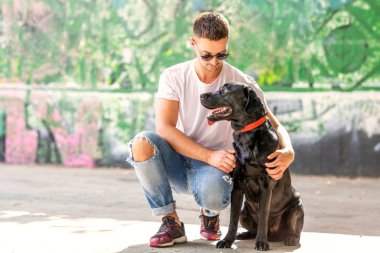 adam sokakta oynarken bir köpek labrador ile