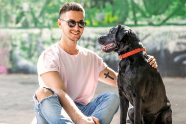 adam sokakta oynarken bir köpek labrador ile