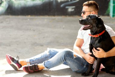 adam parkta oynarken onun köpek labrador ile sarılma