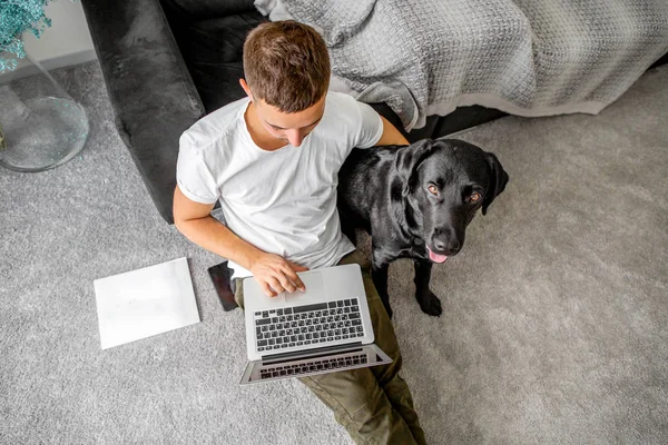 Freelancer Cara Sentado Casa Trabalhando Com Cão Abraço Labrador Preto — Fotografia de Stock