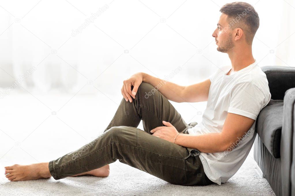 fashion guy sitting on the floor in front of the sun